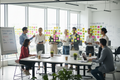 Diverse business team in a transformation planning workshop with sticky notes on glass walls